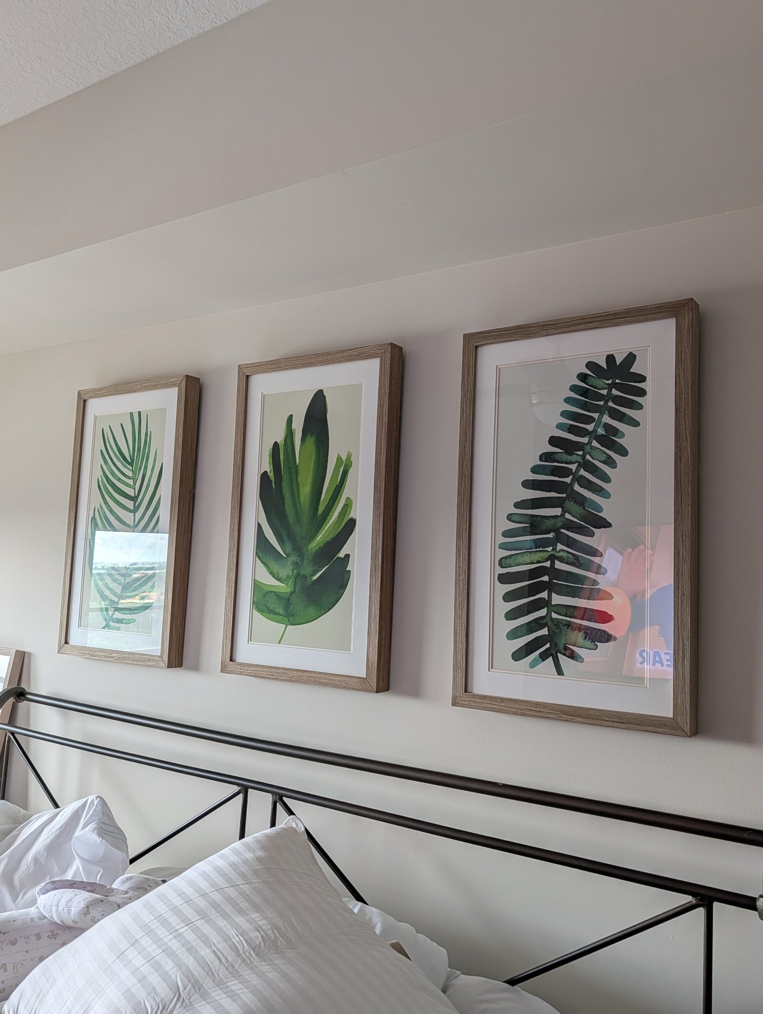 Framed botanical prints hung level on a bedroom wall