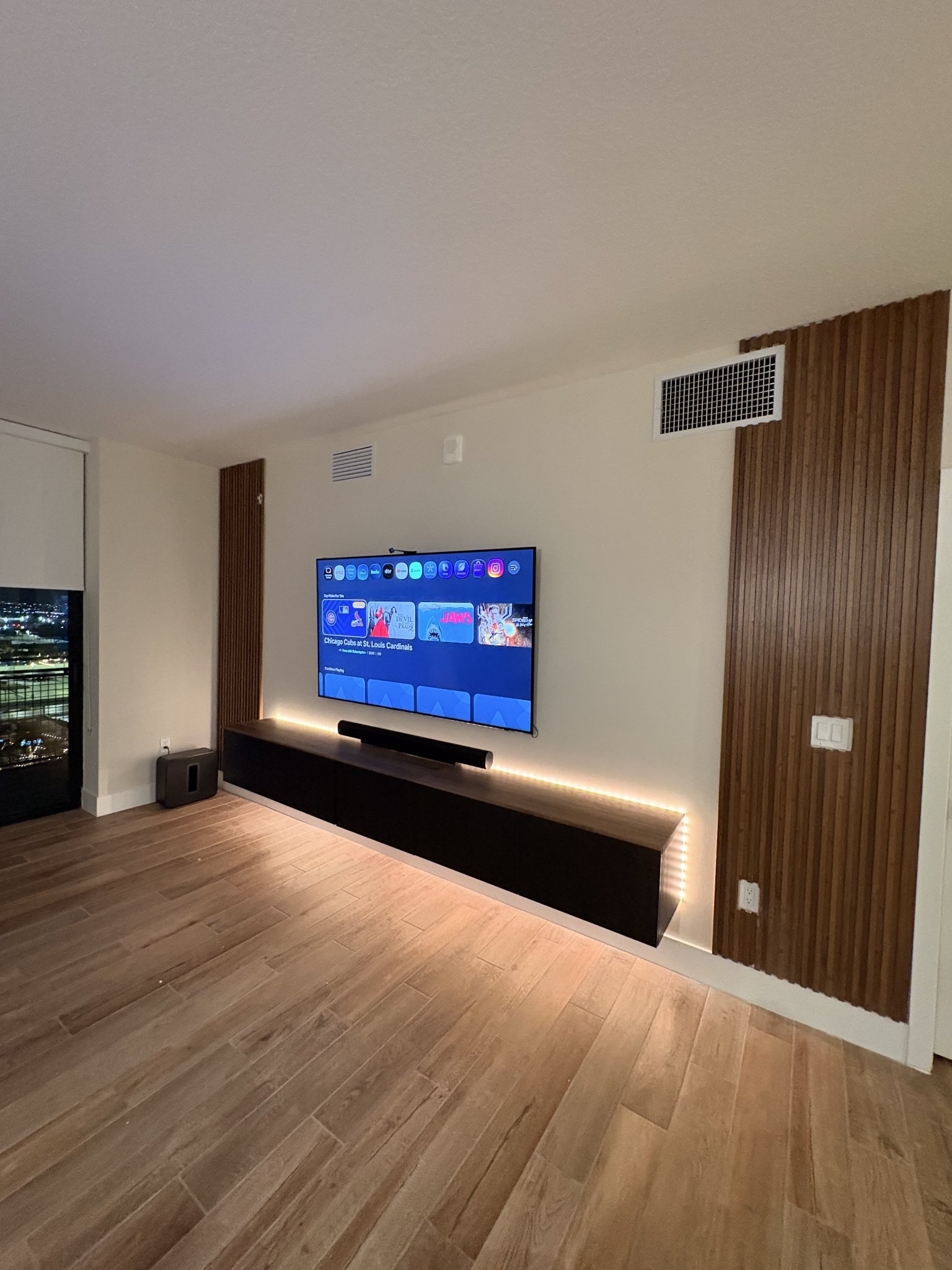 TV mounted on a wood slat accent wall with a floating console, installed by Install Buddies